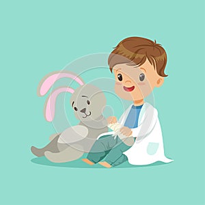 Cute baby boy heals paw of toy bunny. Little doctor and patient concept. Flat design vector illustration