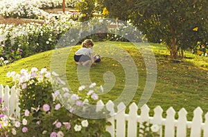 Cute baby boy playing with ball on green grass