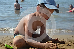 Cute baby boy playing with beach toys on tropical beach. playing on the beach on summer holidays. Children building a