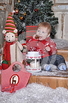 Cute baby boy playing with Christmas tree decoration