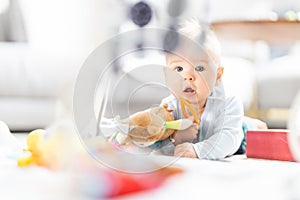 Cute baby boy playing with hanging toys arch on mat at home Baby activity and play center for early infant development