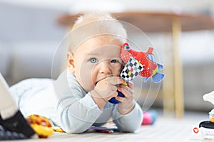 Cute baby boy playing with hanging toys arch on mat at home Baby activity and play center for early infant development