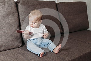 Cute baby boy playing with mobile phone closeup