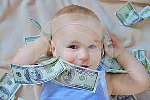 Cute baby boy playing with money, us dollars cash