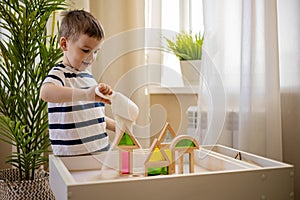 Cute baby boy playing sand table therapy toys developing game at home. Early development