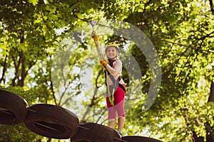 Cute baby boy playing. Small boy enjoy childhood years. Hiking in the rope park girl in safety equipment. Portrait of a