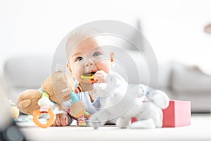 Cute baby boy playing with toys on mat at home Baby activity and play center for early infant development. Baby playing