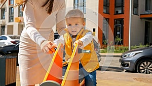 Cute baby boy riding on the bouncy spring rider on the the playground at amusement park. Children playing outdoor, kids outside,