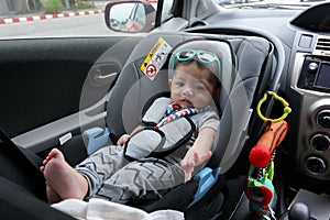 Cute baby boy sitting on car seat safety belt lock protection for drive road trip travel