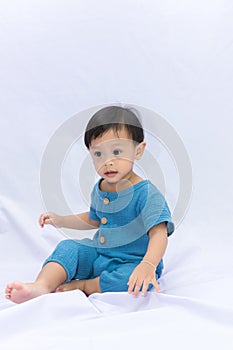 Cute baby Boy sitting on white background. Little baby boy sitting on floor at home. childhood, babyhood and people concept .
