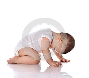 Cute baby boy toddler infant in white body crawling on floor looking down isolated on white background. Happy infancy concept