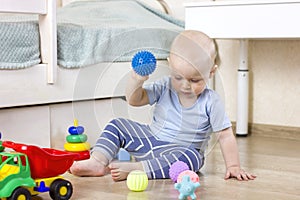 Cute baby boy toddler playing with massage balls.