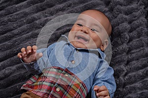 Cute baby boy wearing jeans shirt laughing with copy space