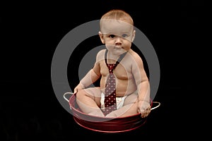 Cute baby boy wearing tie in red pan