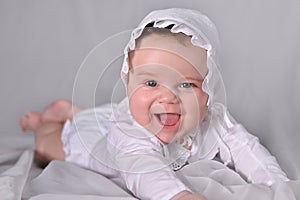 Cute baby boy in white suit crawling