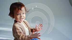 Cute Baby Catching Soap Bubbles in living room