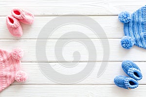 Cute baby clothes for girl and boy on white wooden background top view copyspace