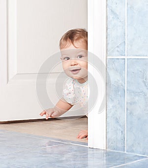 Cute baby crawling through the door