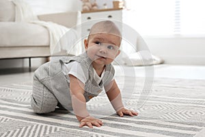 Cute baby crawling on floor at home