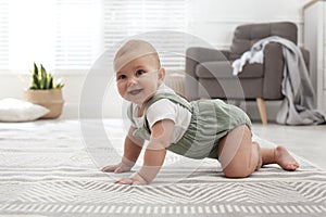 Cute baby crawling on floor at home