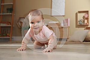 Cute baby crawling on floor at home