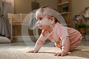 Cute baby crawling on floor at home. Space for text