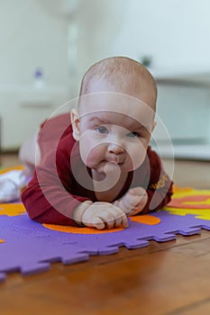 Cute baby crawling on the floor looking to the camera