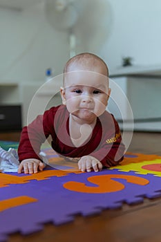 Cute baby crawling on the floor looking to the camera