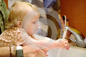 Cute baby and dad washing their hands with soap in bathroom together. Hygiene for little child. Father`s involvement in raising