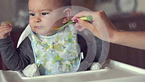 Cute baby does not want to eat her food spoon fed mother problem solids slow motion