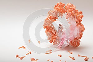 A cute baby doll sitting in a artificial fancy flower garland on