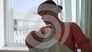 Cute baby falls asleep in his mother's arms.