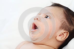 Cute baby is feeling sleeping close up on white bed