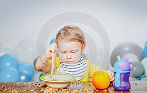 Cute baby food, babies eating. Funny kid boy with plate and spoon.