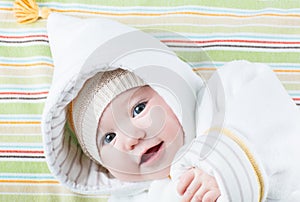 Cute baby in a funny hat on a colorful blanket