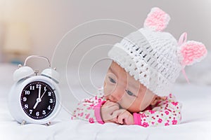 cute baby girl and alarm clock wake up in the morning