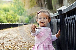 Cute baby girl with autumn leaves