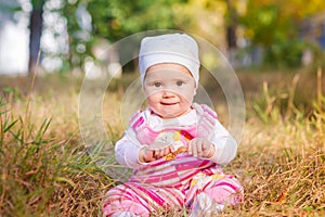 Cute baby girl in autumn leaves.