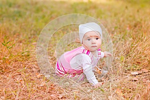 Cute baby girl in autumn leaves.