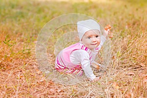 Cute baby girl in autumn leaves.