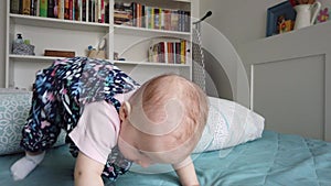 Cute baby girl on bed. Adorable child in home.