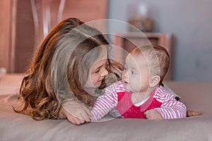 Cute baby girl celebrating birth day together close to red balloons.Lovely scene of baby on sofa divan with presents and