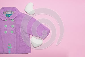 Cute baby girl clothes and accessories bright coat soft hearts on pink background.Happy Valentine day concept copy space