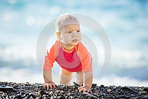 Cute baby girl crawling on beach