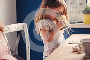 Lindo un nino bebiendo té desayuno en soleado La cocina 