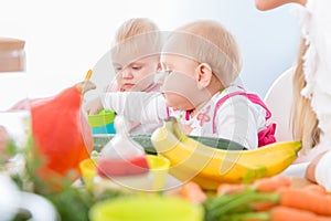 Cute baby girl eating healthy solid food in a modern daycare cen