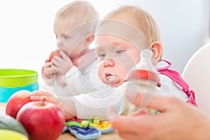 Cute baby girl eating healthy solid food in a modern daycare center