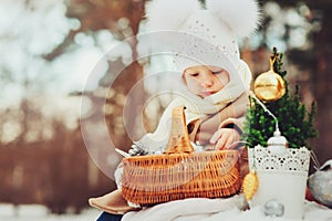 Cute baby girl enjoying winter walk in snowy park, wearing warm hat