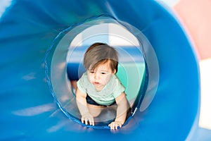 Cute baby girl exploring a tunnel