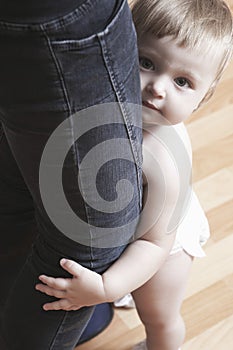 Cute Baby Girl Holding Mother's Legs